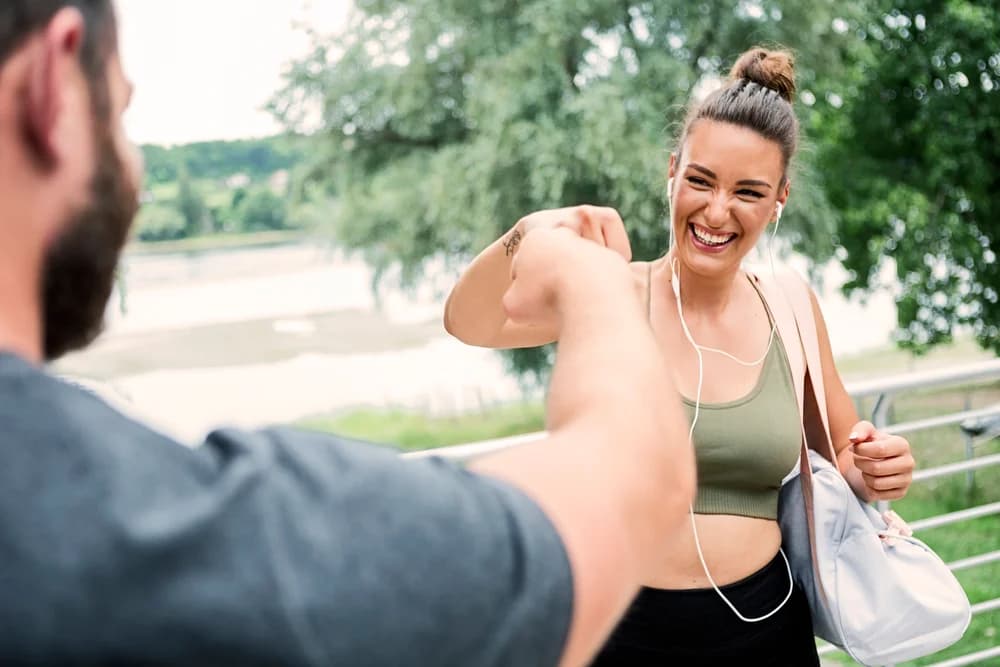 A coaching fist bump between two people outdoors