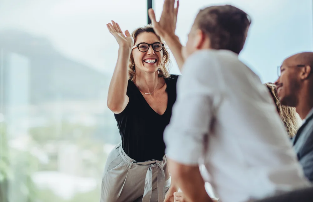A high five in a leadership team meeting